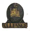 Embossed sheet brass British fire plaque with black painted details. (Flat sheet metal emblems may be called fire plaques.)