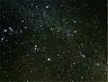The brightest meteor, a fireball, leaves a persistent smoky trail drifting in high-altitude winds, which is seen on the right side of the image.