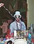 Young man wears a party top hat at a New Year's Party.