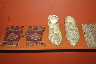 Silk liturgical gloves (left) of Cardinal Pierre de Foix (15th century), dyed crimson with P. hamelii carmine[6]