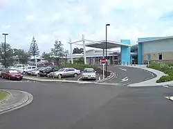 a parking lot and driveway with covered entry area outside a modern-style building